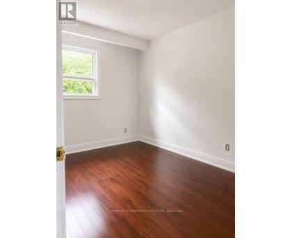 A room with wooden floors and a window letting in light.