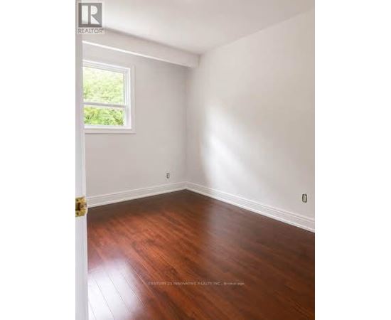 A room with wooden floors and a window letting in light.
