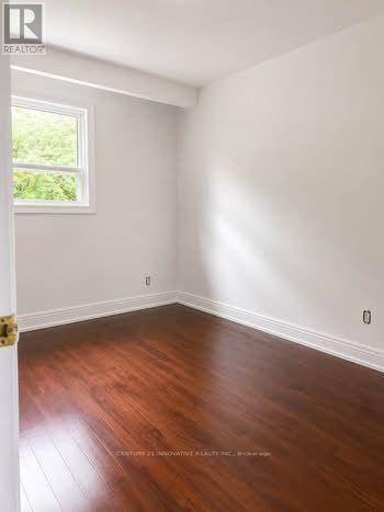 A room with wooden floors and a window letting in light.