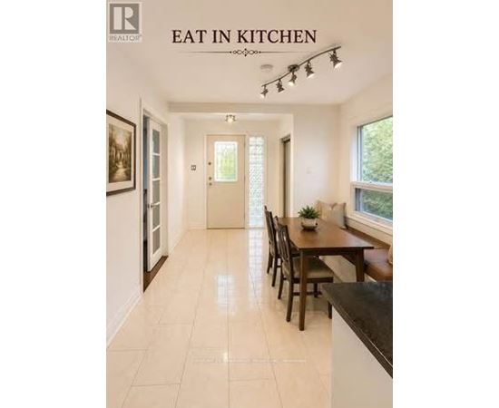 A kitchen with a table and chairs in the middle of the room.