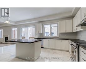A spacious kitchen with marble countertops and white cabinets.