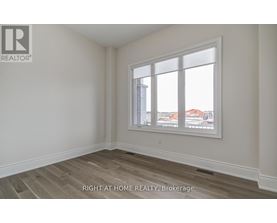 A room with a window showing a view of buildings outside.