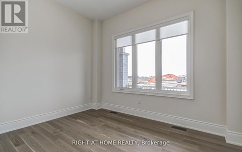 A room with a window showing a view of buildings outside.