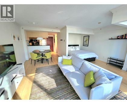 A living room with a white couch and a rug.