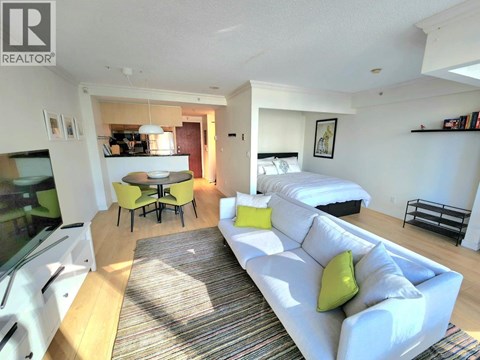 A living room with a white couch and a rug.