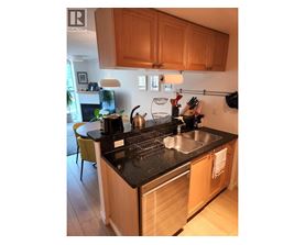 A kitchen with wooden cabinets and a black countertop.