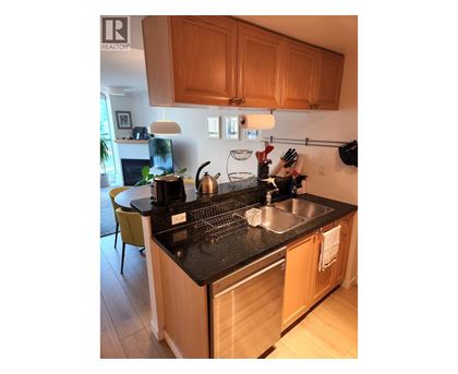 A kitchen with wooden cabinets and a black countertop.
