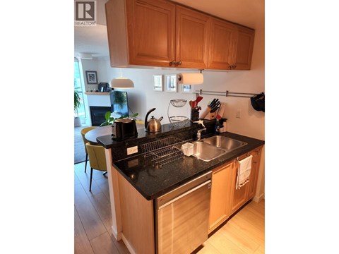 A kitchen with wooden cabinets and a black countertop.