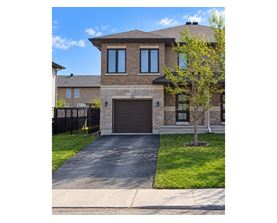 A house with a brown garage door and a black fence.