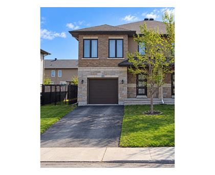 A house with a brown garage door and a black fence.
