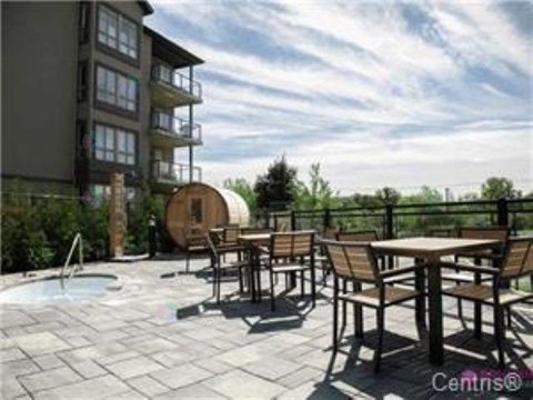 A patio with a table and chairs overlooking a pool.