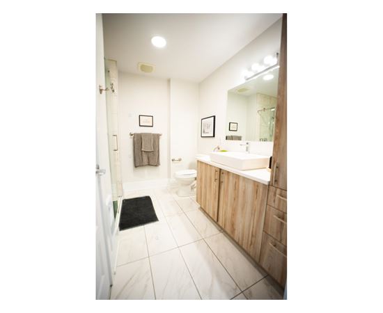 A bathroom with a toilet, sink, and mirror.