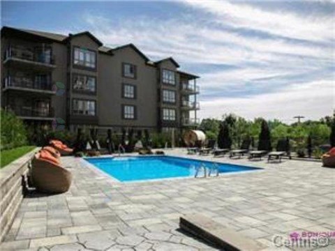 A large apartment complex with a pool in the foreground.
