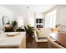 A modern living room with a dining table and chairs.
