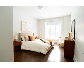A bedroom with a large bed and a window.