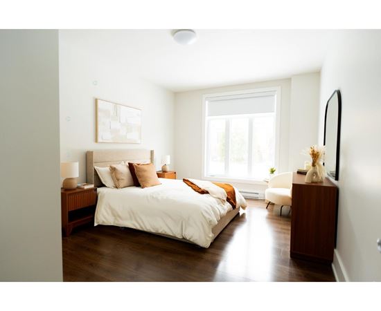 A bedroom with a large bed and a window.