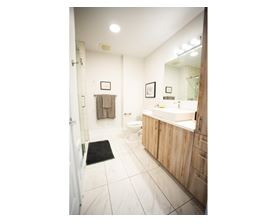 A bathroom with a toilet, sink, and mirror.
