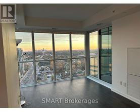 A room with a view of the cityscape through large windows.