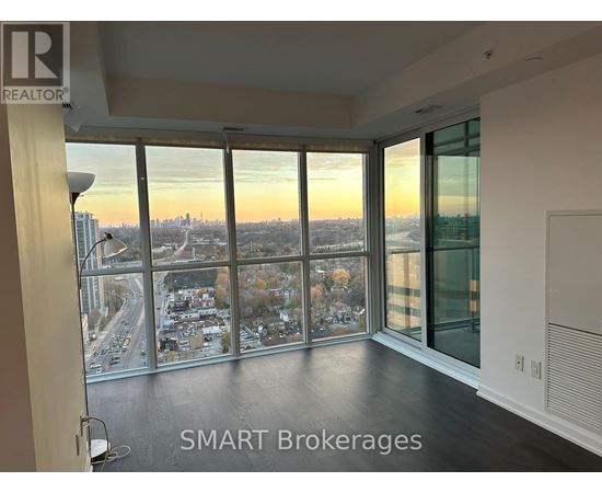 A room with a view of the cityscape through large windows.