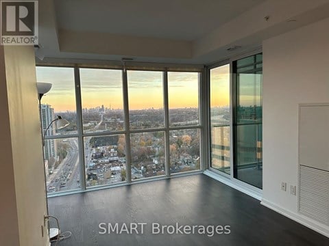 A room with a view of the cityscape through large windows.