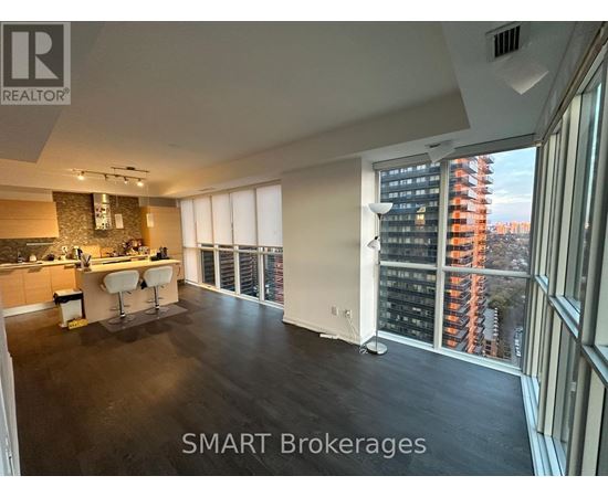 A spacious kitchen and living room with a view of a city skyline.