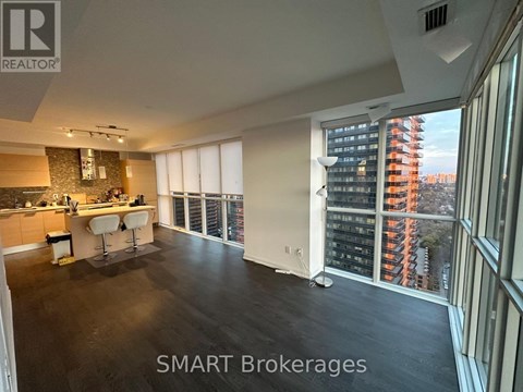 A spacious kitchen and living room with a view of a city skyline.