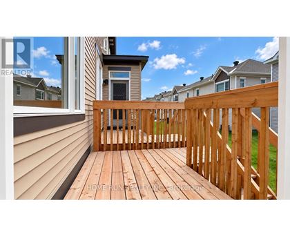 A wooden deck with a railing and a view of the sky.
