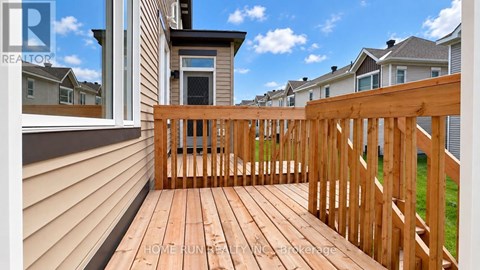 A wooden deck with a railing and a view of the sky.
