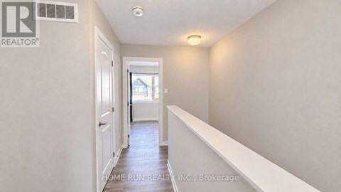 A hallway with a door on the left and a window on the right.
