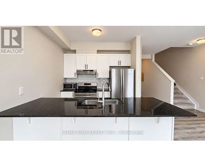A kitchen with white cabinets and a black countertop.