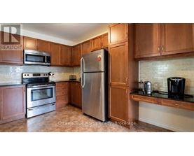 A kitchen with a stainless steel refrigerator, microwave, oven, and coffee maker.