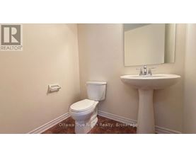 A bathroom with a toilet, sink, and mirror.