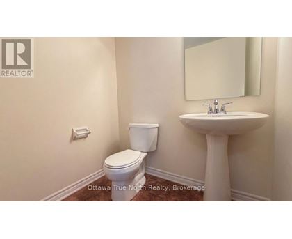 A bathroom with a toilet, sink, and mirror.