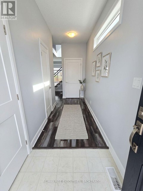A hallway with a rug on the floor and pictures on the wall.