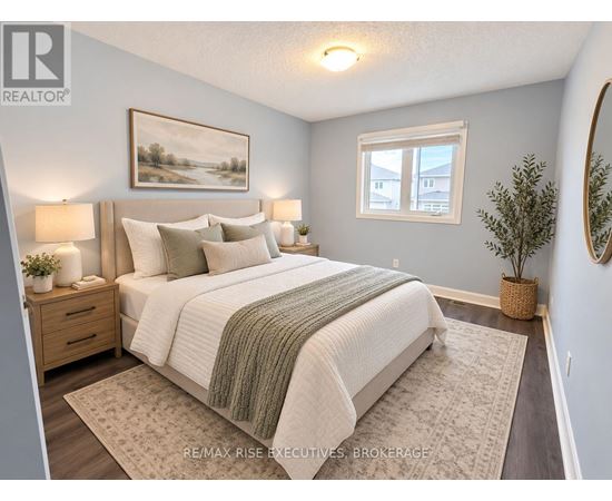 A bedroom with a large bed and a painting on the wall.
