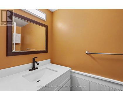 A bathroom with a white sink and a mirror.