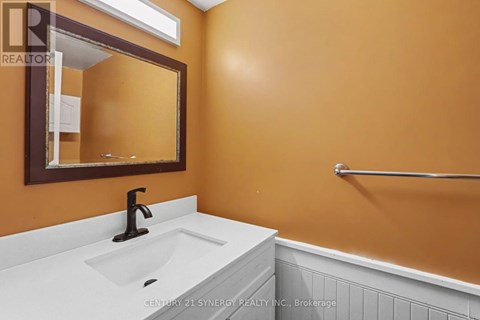 A bathroom with a white sink and a mirror.