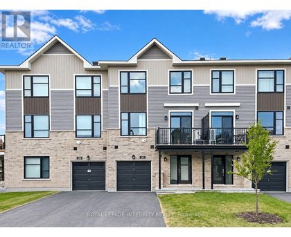 A modern two-story residential building with a balcony on the second floor.