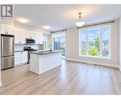 A spacious kitchen with white cabinets and a large island.