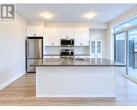A modern kitchen with white cabinets and stainless steel appliances.