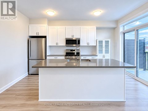 A modern kitchen with white cabinets and stainless steel appliances.