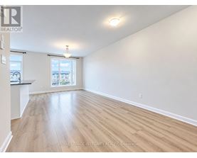 A spacious room with wooden flooring and a window overlooking a balcony.