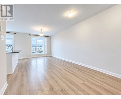 A spacious room with wooden flooring and a window overlooking a balcony.