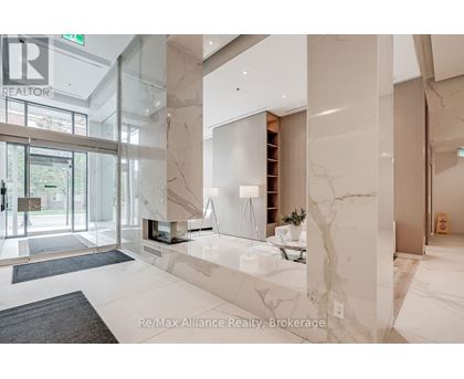 A spacious lobby with marble floors and a glass wall.