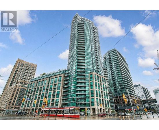 A modern glass building stands tall in a cityscape.