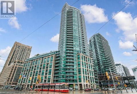 A modern glass building stands tall in a cityscape.
