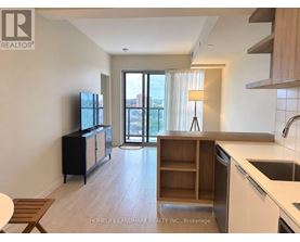 A kitchen with a sink, stove, and cabinets with a sliding glass door leading to a balcony.