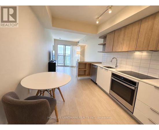 A kitchen with a table and chairs in the foreground and a window in the background.