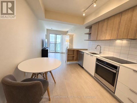 A kitchen with a table and chairs in the foreground and a window in the background.