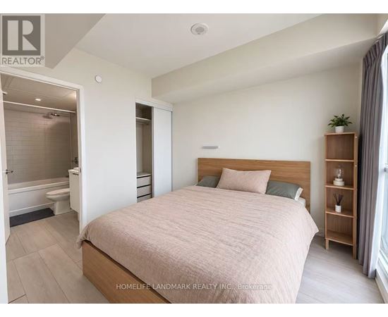 A bedroom with a large bed and a wooden bookshelf.